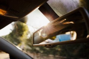 sun glare from rearview mirror while driving during long weekend