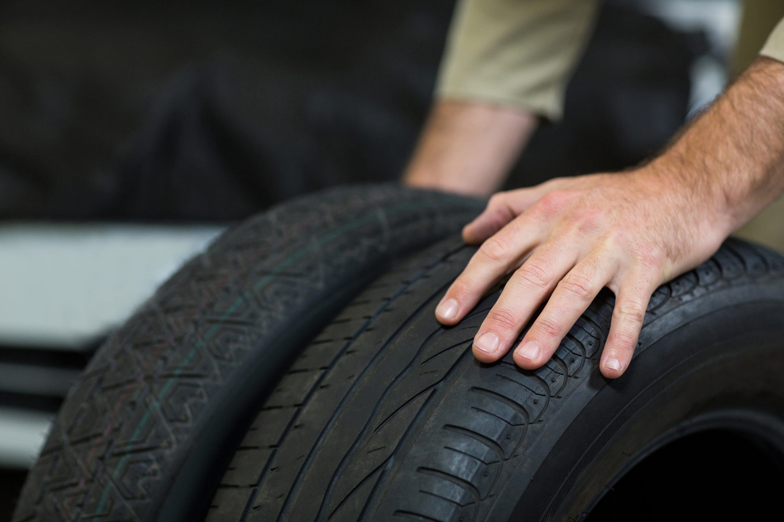 Hands of mechanic touching tyres in repair garage, tyres near me, tyre repair near me